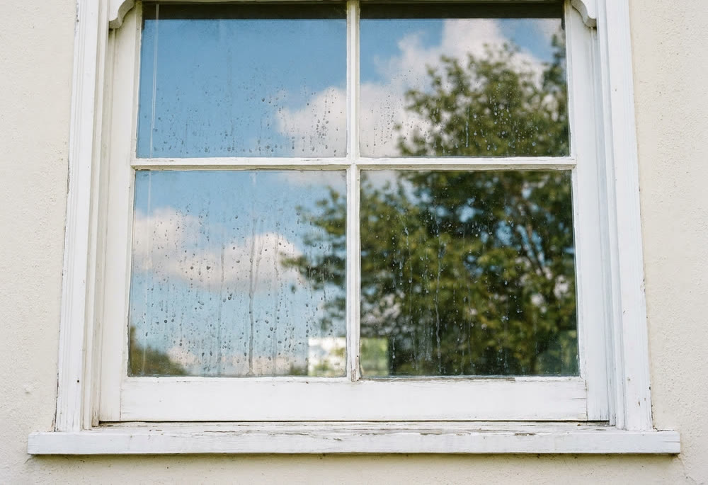 A window covered in white hard-water mineral spots