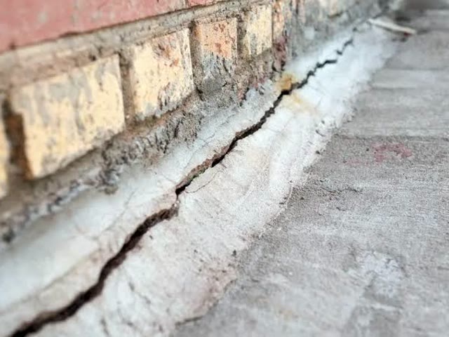 A crack opening at the foundation from pooling water