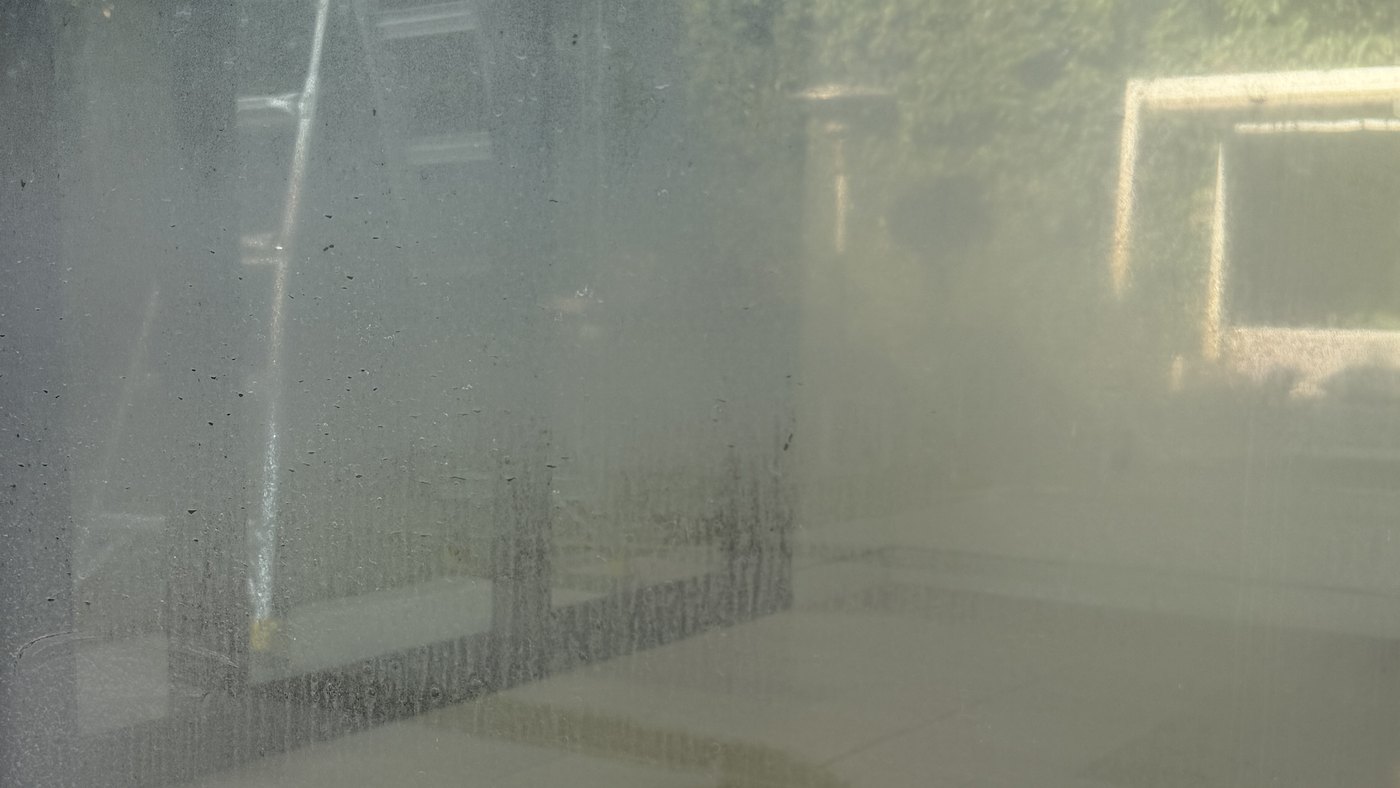 A window covered in white hard-water mineral spots
