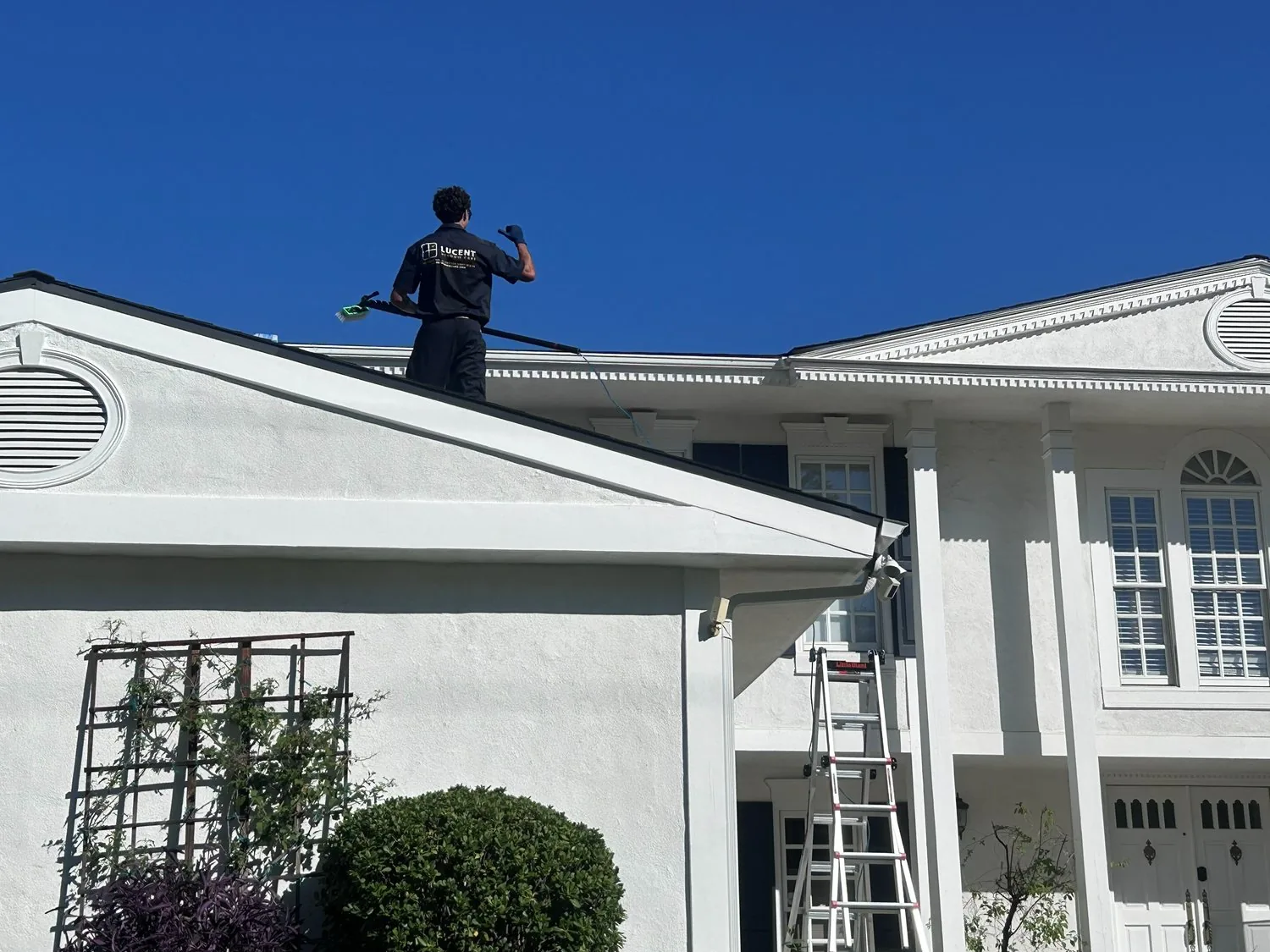 Lucent technician cleaning windows on a Glendale home with a water-fed pole