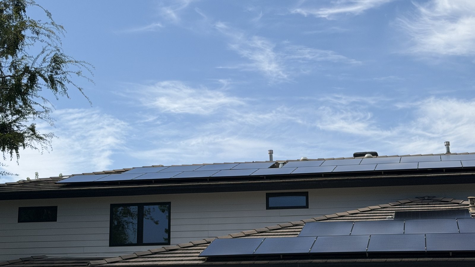 Clean solar panels on a tile roof under blue sky