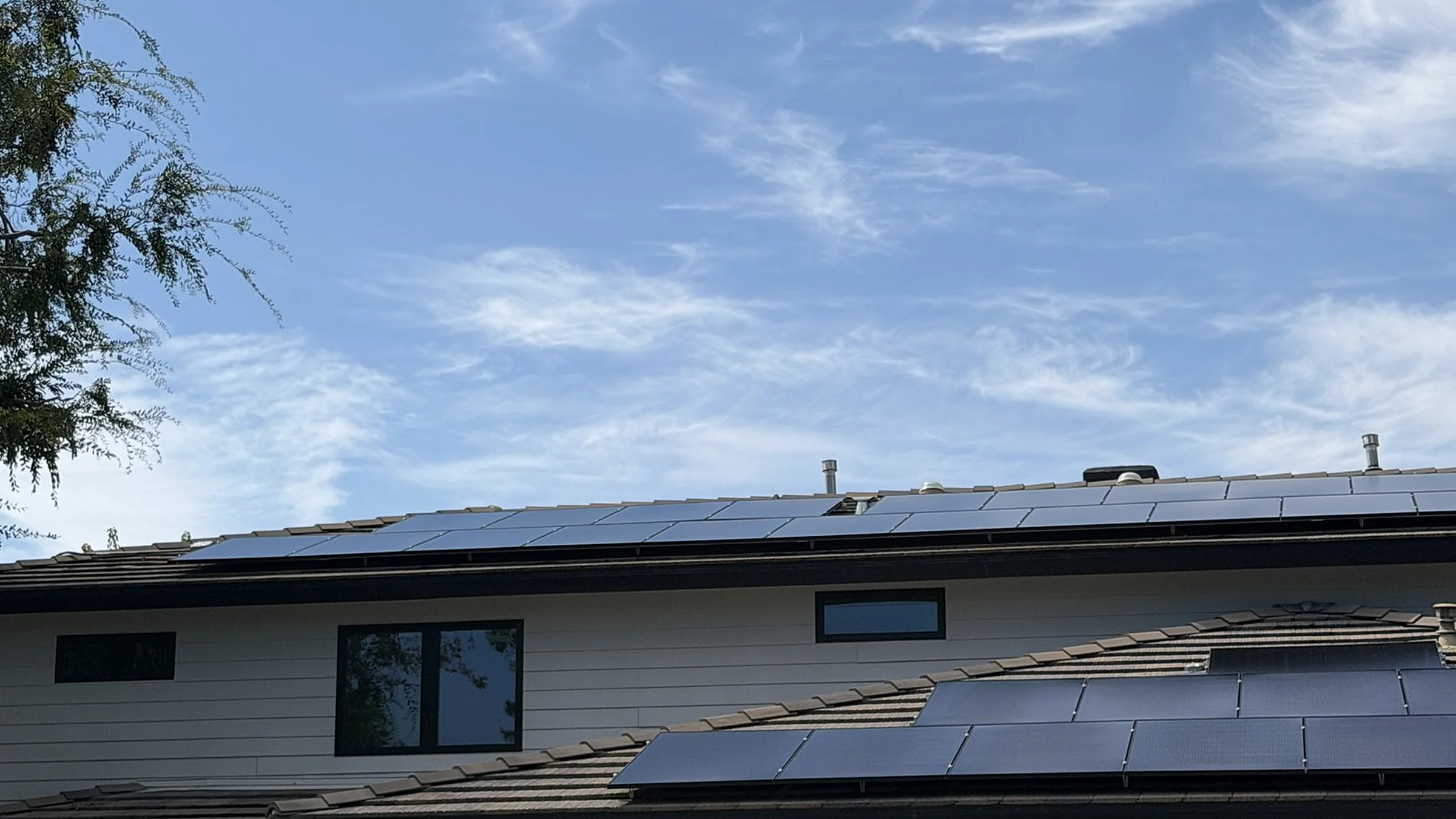 Clean solar panels on a tile roof under blue sky
