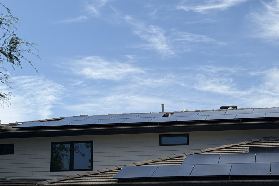 Clean solar panels on a tile roof under blue sky